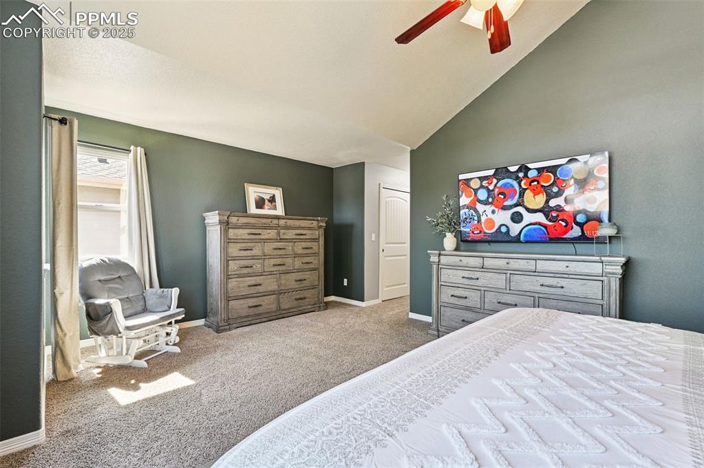 Image 11 of 39: Bedroom featuring carpet, ceiling fan, and high vaulted ceiling