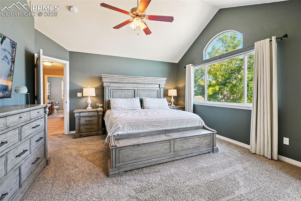 Image 12 of 39: Bedroom featuring light colored carpet, a ceiling fan, and high vaulted cei