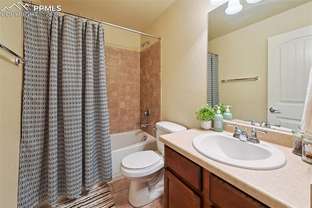 Image 20 of 39: Full bathroom with a textured wall, vanity, shower / bath combo with shower