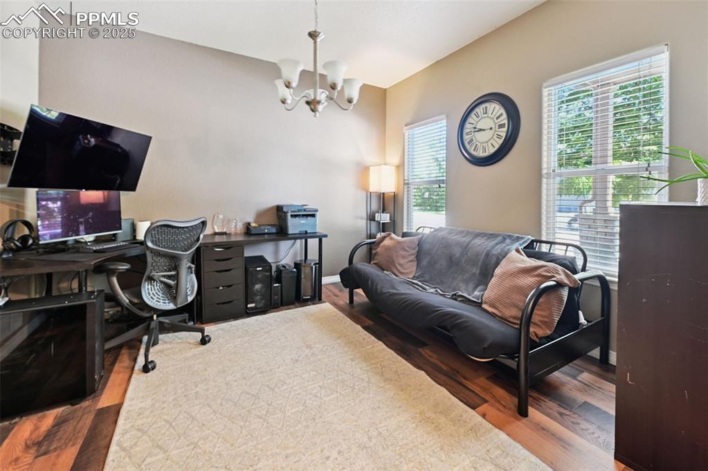 Image 21 of 39: Office featuring a chandelier and wood finished floors