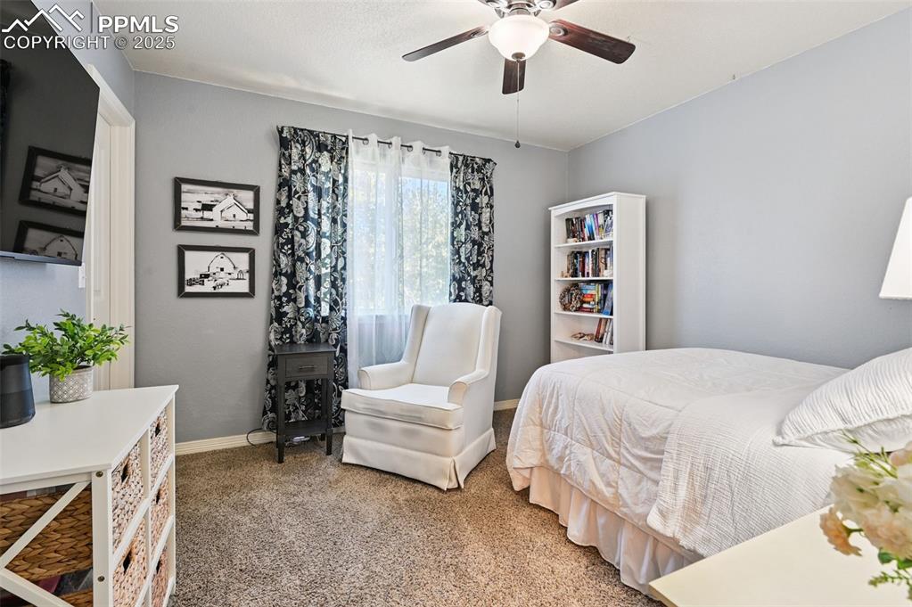 Image 27 of 39: Carpeted bedroom with baseboards and a ceiling fan