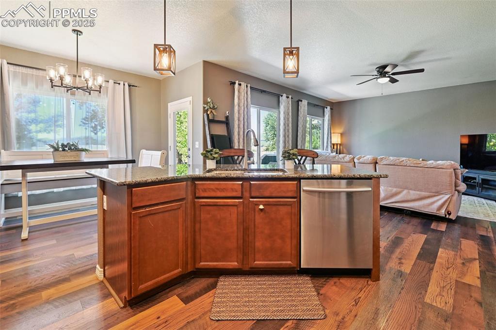Image 6 of 39: Kitchen featuring pendant lighting, dishwasher, an island with sink, health