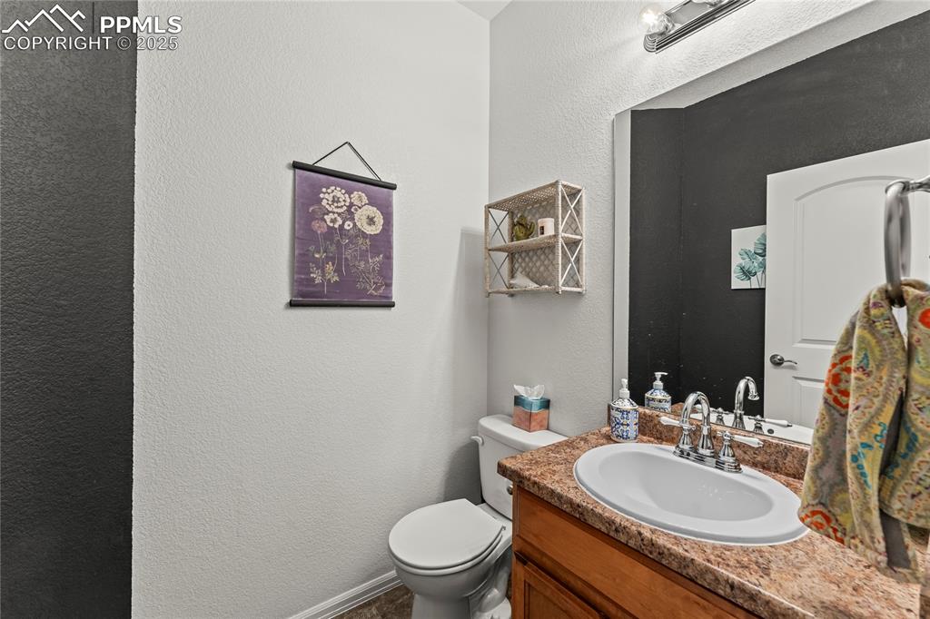 Image 15 of 39: Half bath with a textured wall and vanity
