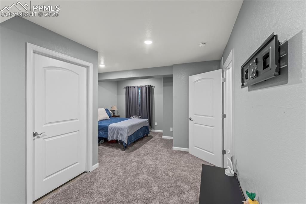 Image 18 of 39: Bedroom featuring light carpet, a textured wall, and recessed lighting