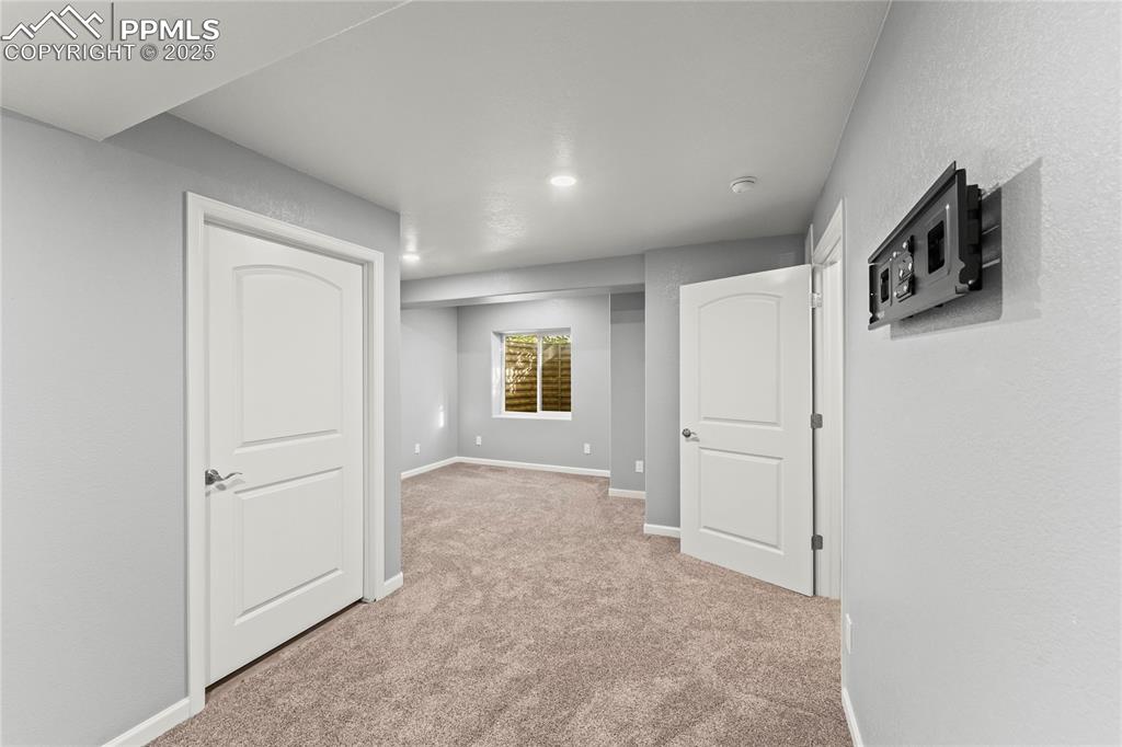 Image 19 of 39: Below grade area with light carpet and recessed lighting