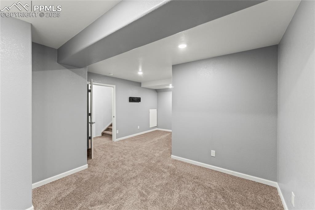 Image 22 of 39: Finished below grade area with light colored carpet and stairs