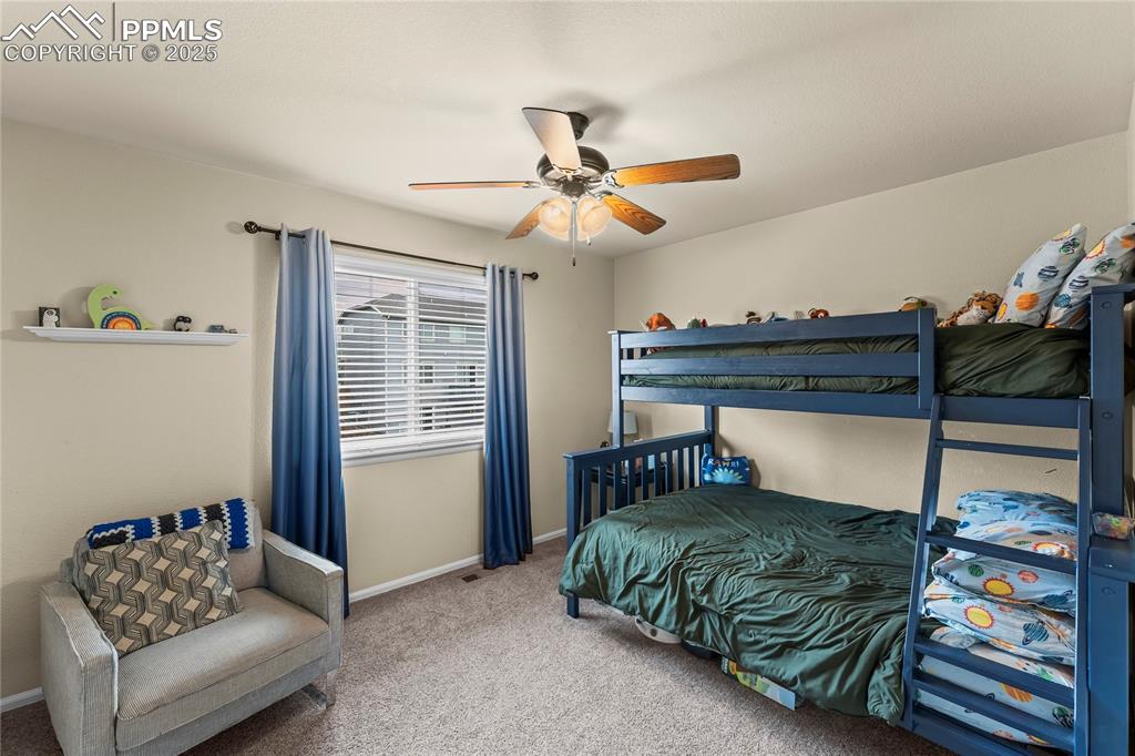 Image 29 of 39: Carpeted bedroom with a ceiling fan and baseboards
