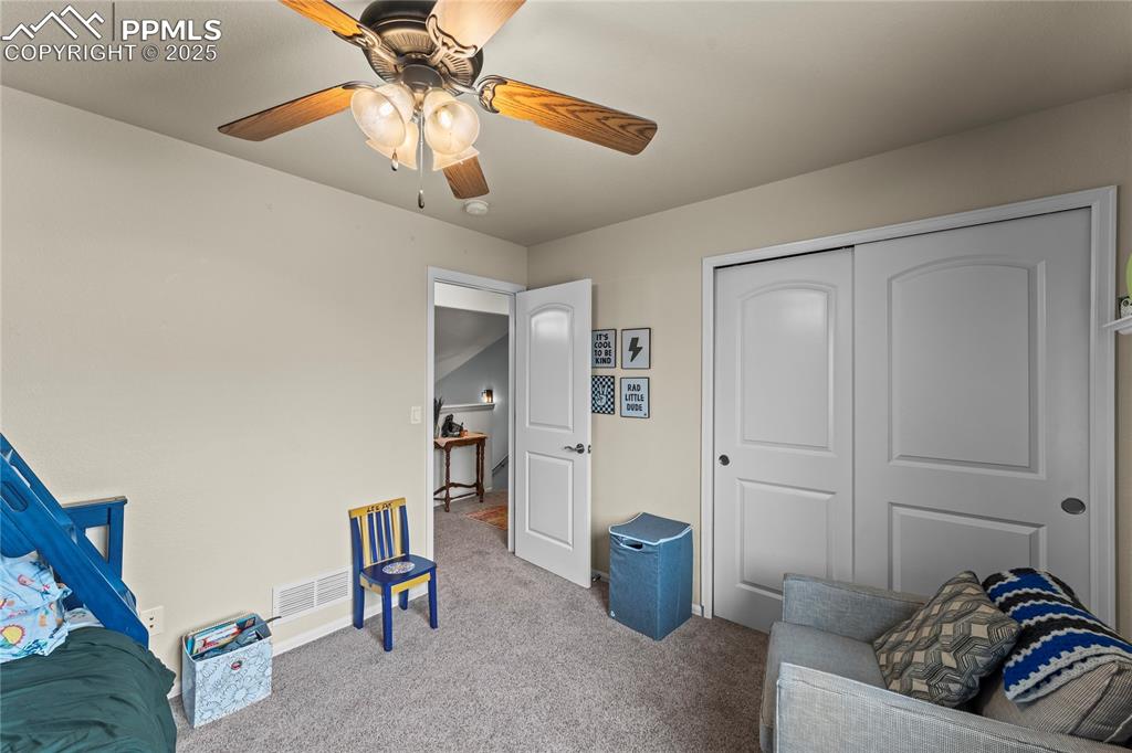 Image 30 of 39: Living area featuring carpet floors and a ceiling fan