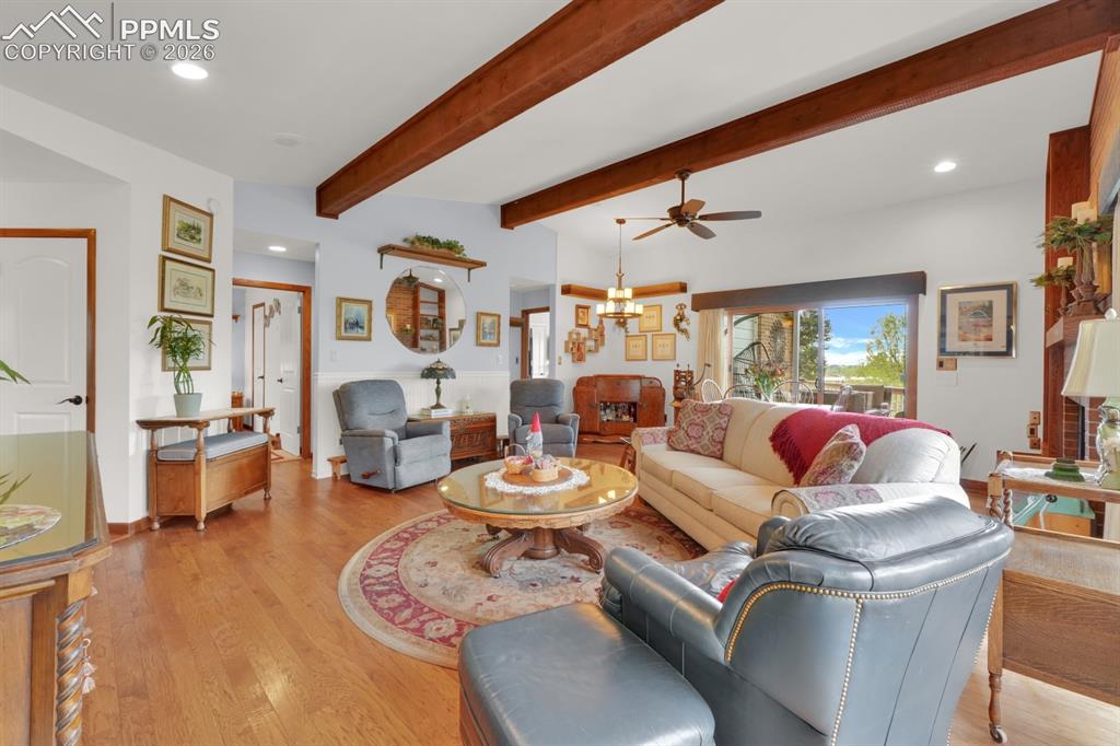 Image 7 of 42: Living room with wood flooring and exposed wood beams