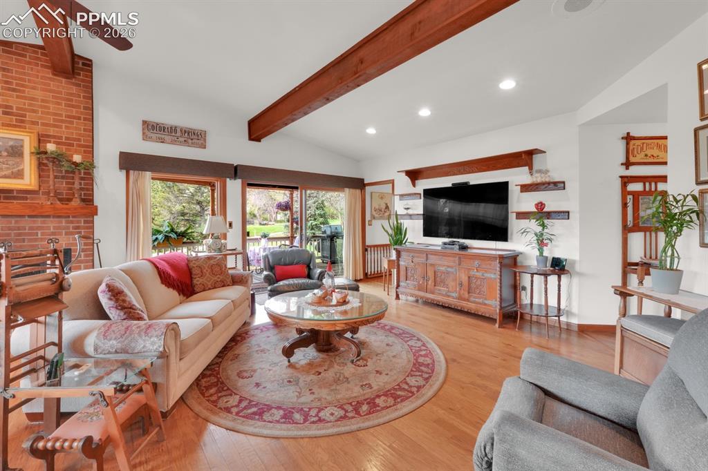 Image 8 of 42: Living room with wood flooring and exposed wood beams