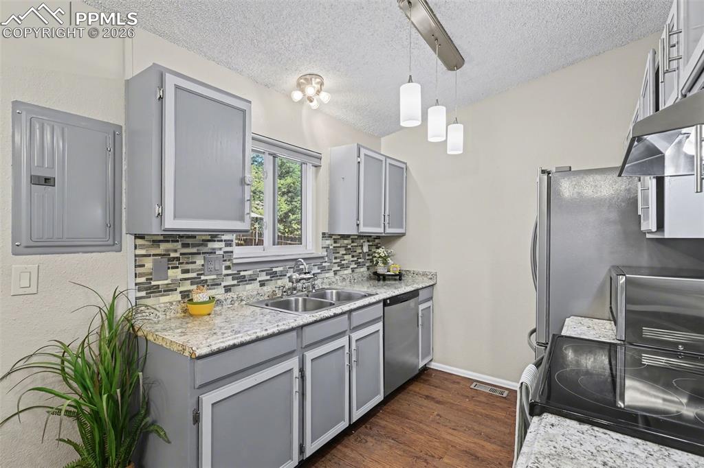Image 9 of 31: Kitchen with window above sink that looks out to back decking