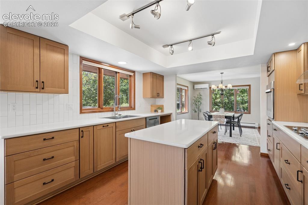 Image 13 of 50: Kitchen featuring wood-finish cabinetry, white countertops, a center island