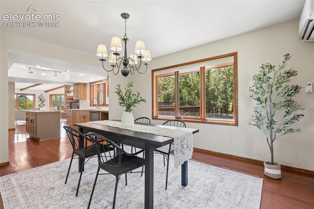 Image 16 of 50: Hardwood-style flooring, large windows with natural wood trim, open concept