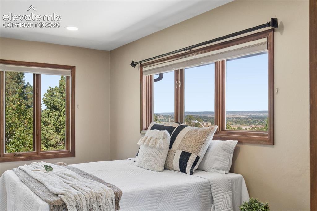 Image 23 of 50: Recessed ceiling lighting, wood-framed windows, and neutral wall tones