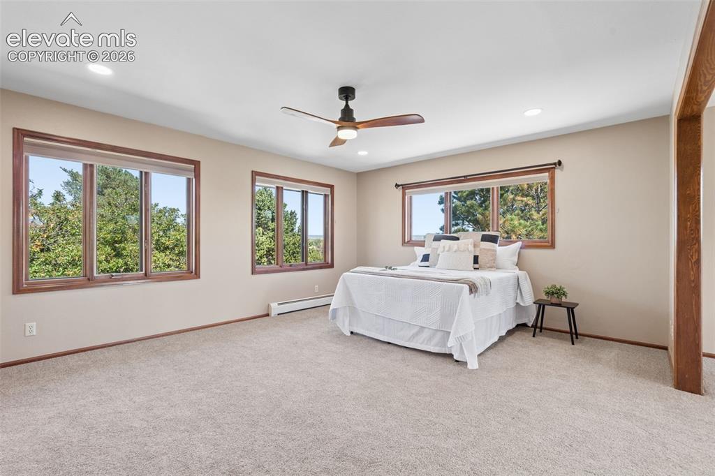 Image 24 of 50: Recessed lighting, ceiling fan, and multiple windows with wood-finish trim