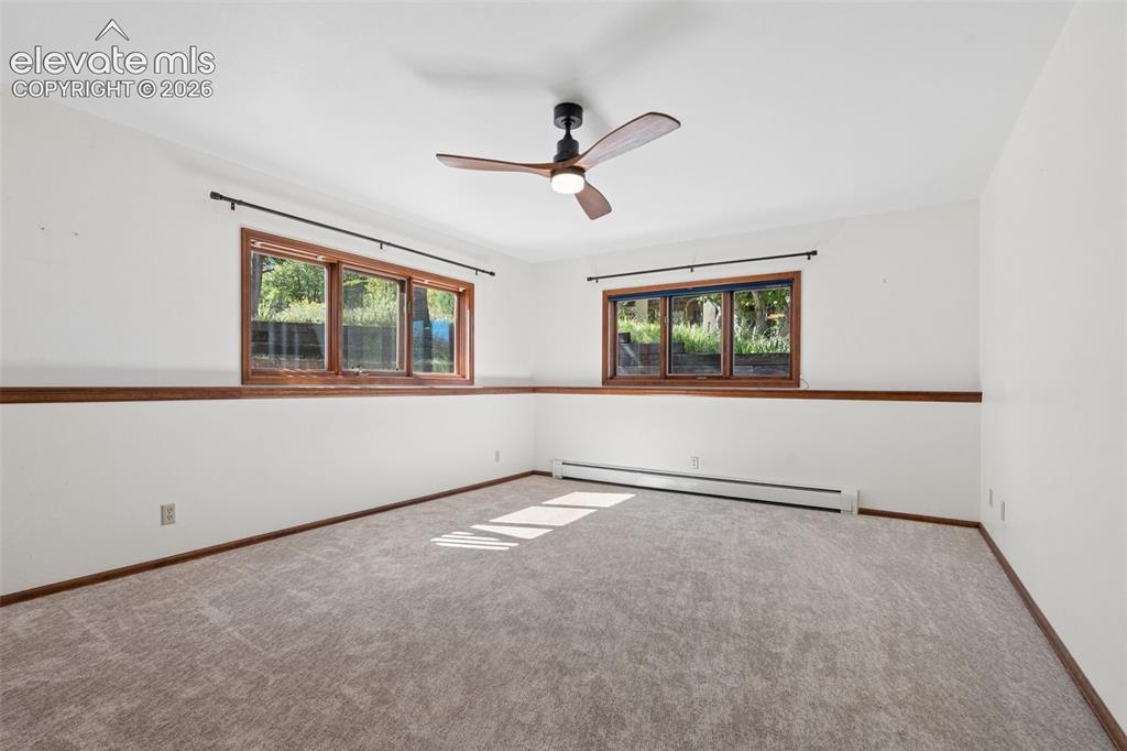 Image 38 of 50: Carpeted interior with wood trim and white walls