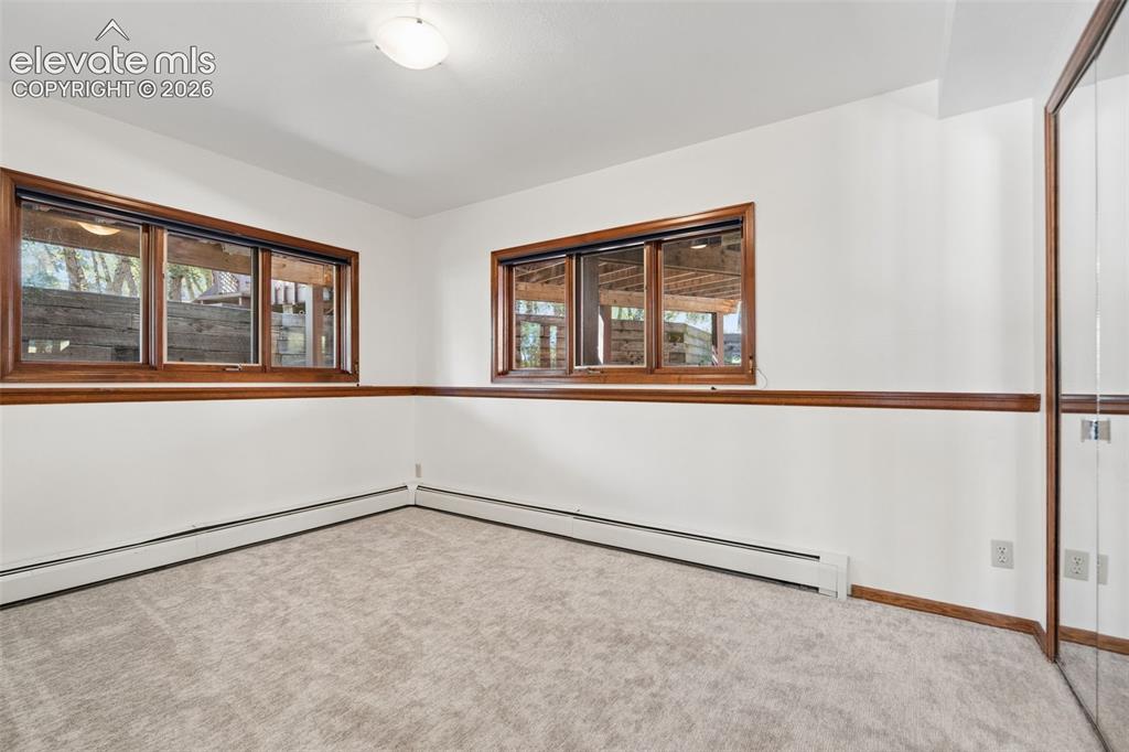 Image 40 of 50: Light-colored carpeting, white painted walls, wood-finish window trim, mult