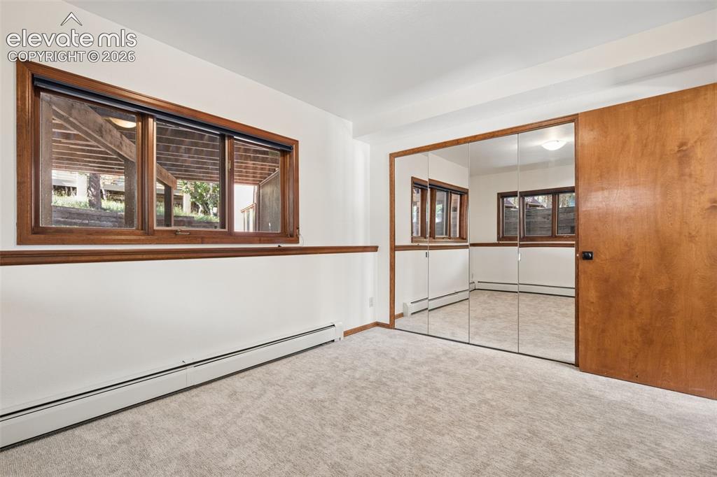 Image 41 of 50: Carpeted room featuring a large window with wood trim, wood chair rail, and