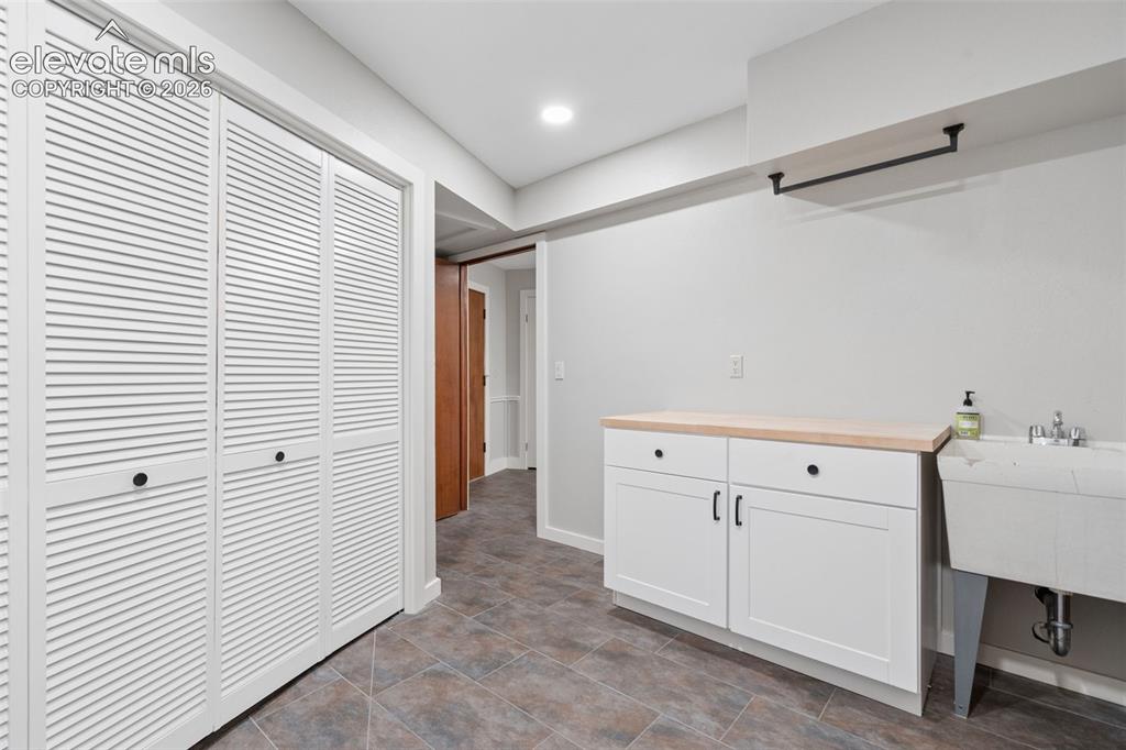 Image 43 of 50: White louvered bi-fold doors, recessed lighting, tile flooring, white cabin