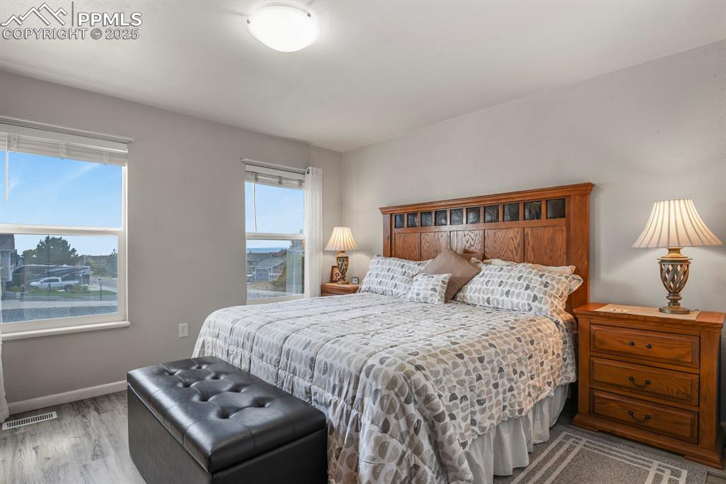 Image 12 of 31: Primary bedroom with two nice sized windows and an ensuite bathroom