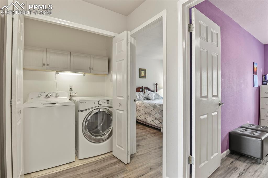 Image 21 of 31: Laundry area on upper level featuring built in cabinets and the washer (new