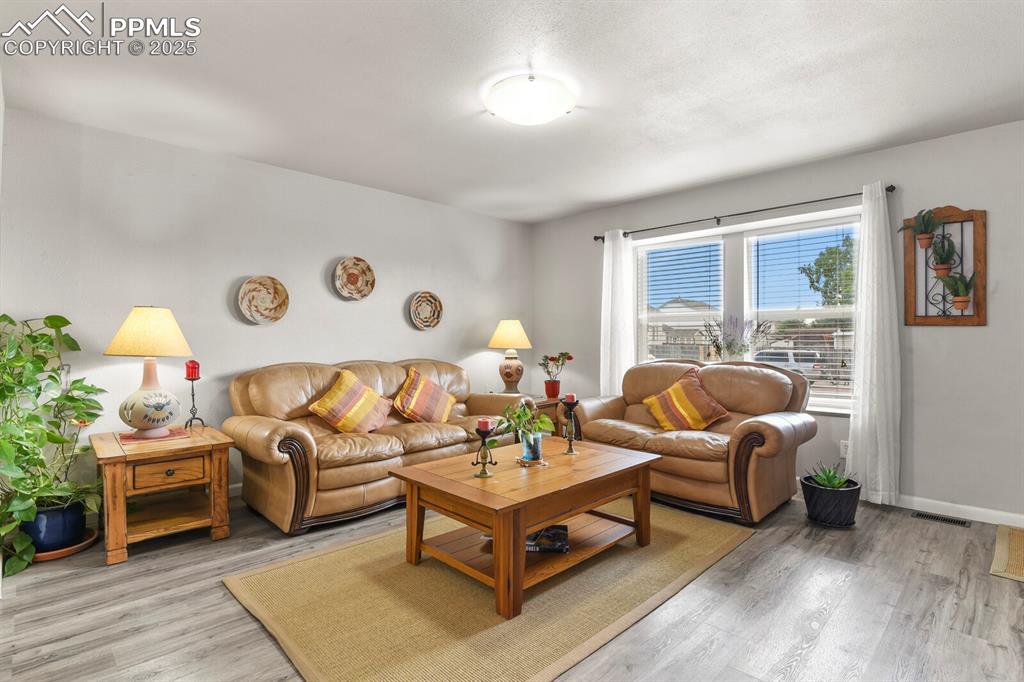 Image 4 of 31: Living room featuring nice window and vinyl wood-style flooring