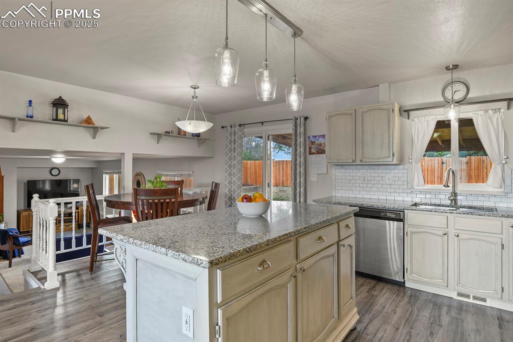 Image 8 of 31: Open concept kitchen featuring a nice island with pendant lighting, stone c