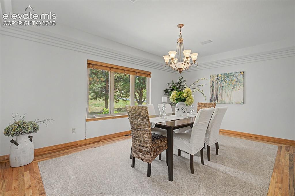 Image 20 of 50: Dining space featuring wood-finish flooring, a multi-pane window with wood-