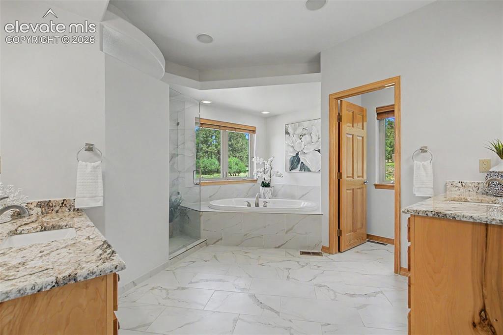Image 24 of 50: Bathroom featuring a freestanding soaking tub, a clear glass shower enclosu
