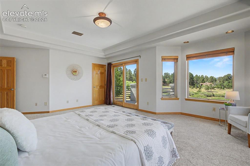Image 25 of 50: Spacious room with tray ceiling and recessed lighting