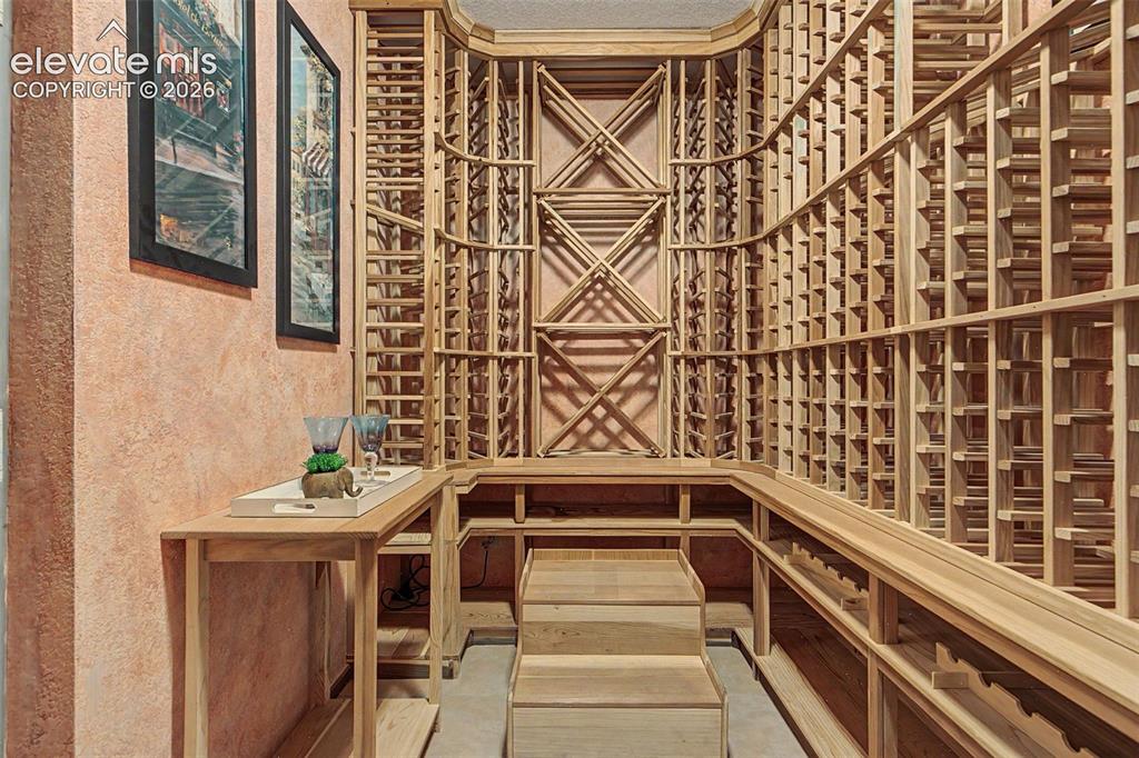 Image 35 of 50: Dedicated wine cellar featuring extensive light wood racking, built-in disp