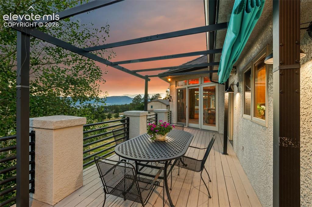Image 5 of 50: Expansive outdoor deck featuring composite decking, a metal pergola, and st
