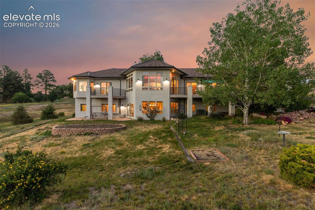Image 50 of 50: Multi-level residence featuring a stucco exterior and a dark shingle roof
