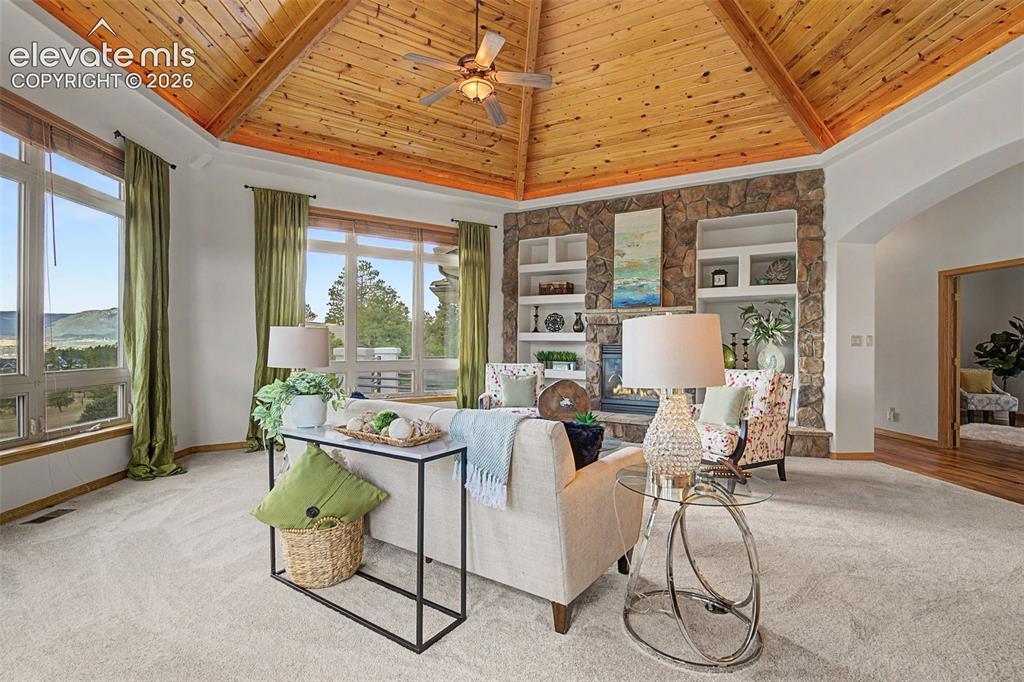 Image 7 of 50: Living area featuring a vaulted wood-paneled ceiling with exposed beams, a