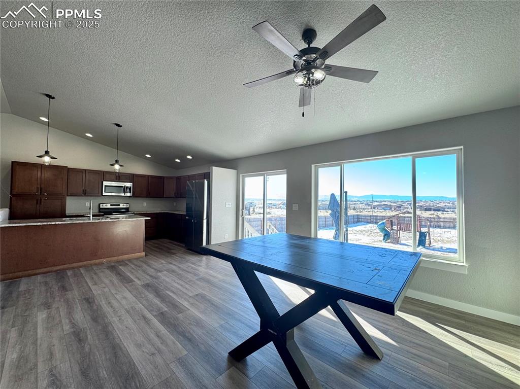 Image 7 of 27: Kitchen overlooks large dining/living area, big Mountain Views along back o
