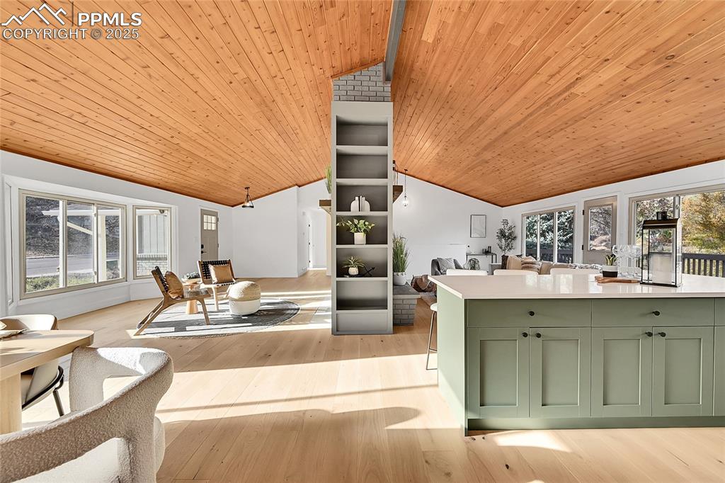 Image 11 of 40: Living area with wooden ceiling and light wood finished floors