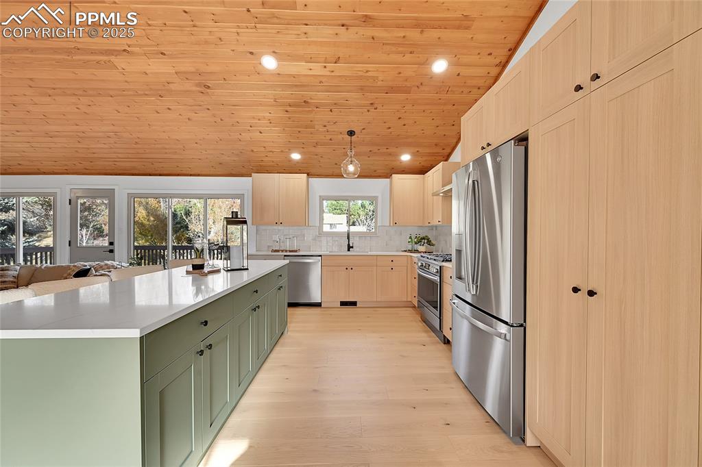 Image 12 of 40: Kitchen with recessed lighting, wooden ceiling, green cabinets, stainless s