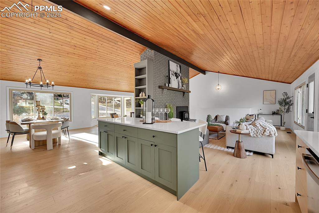 Image 13 of 40: Kitchen with decorative light fixtures, green cabinets, open floor plan, a 
