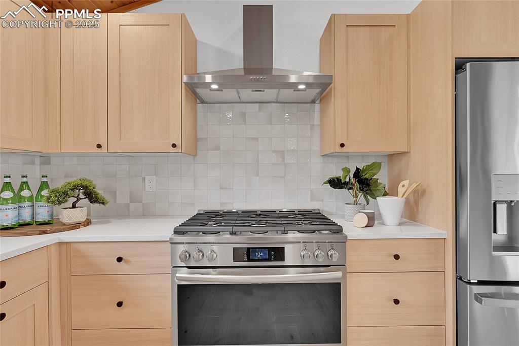 Image 14 of 40: Kitchen featuring light brown cabinets, appliances with stainless steel fin