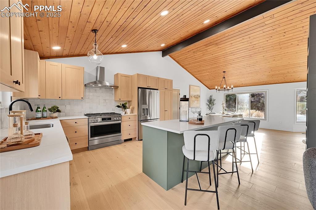 Image 2 of 40: Kitchen with pendant lighting, backsplash, stainless steel appliances, ligh