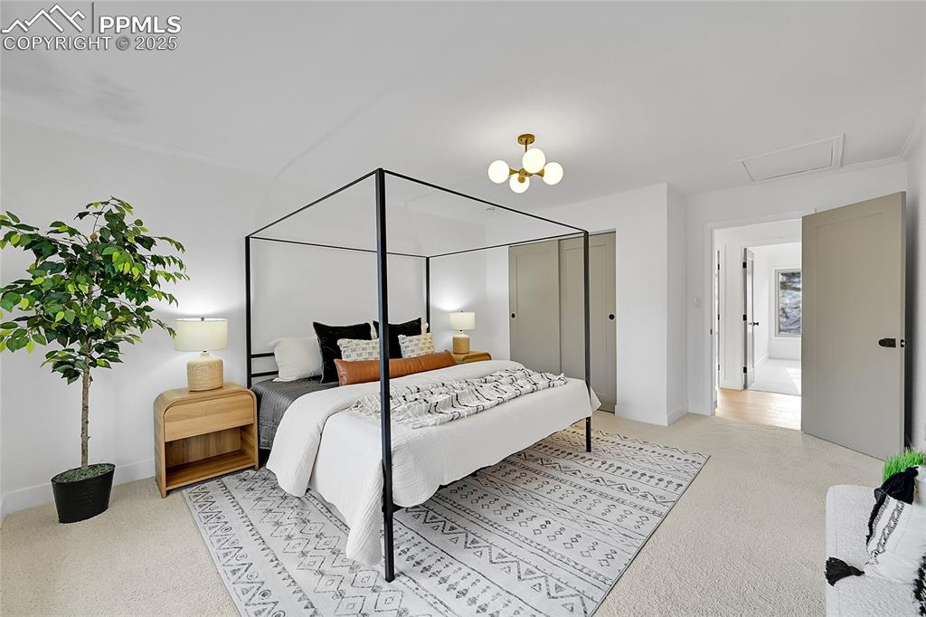 Image 23 of 40: Bedroom featuring light colored carpet, a chandelier, and attic access