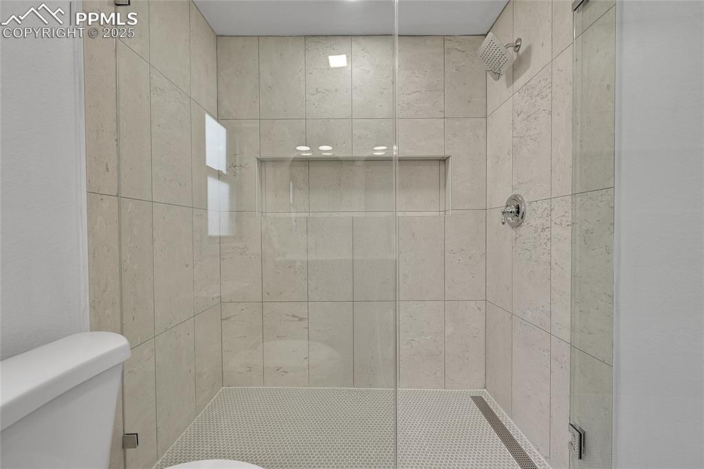 Image 26 of 40: Bathroom with a shower stall and toilet