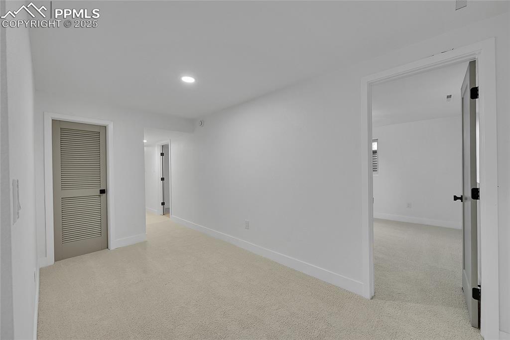 Image 31 of 40: Empty room with light carpet and recessed lighting