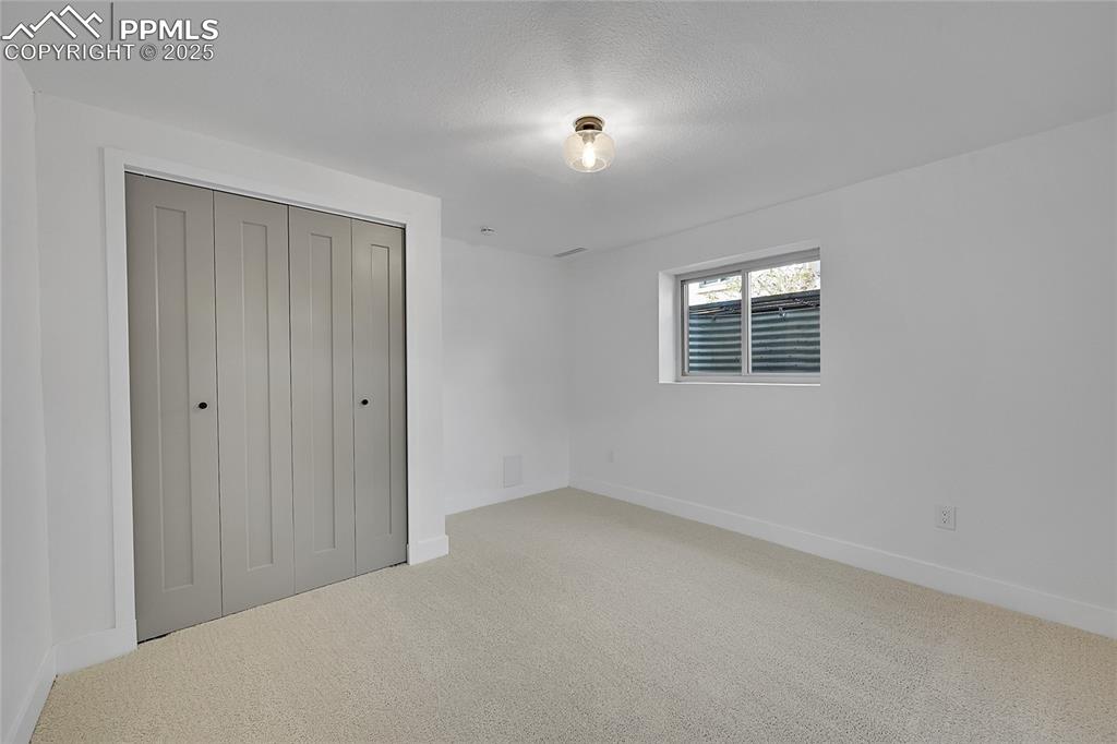 Image 32 of 40: Unfurnished bedroom with carpet flooring and a closet