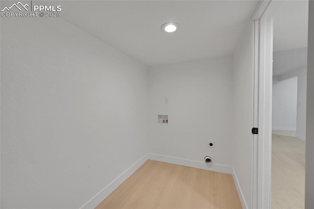 Image 33 of 40: Washroom featuring hookup for a washing machine, light wood-style floors, a