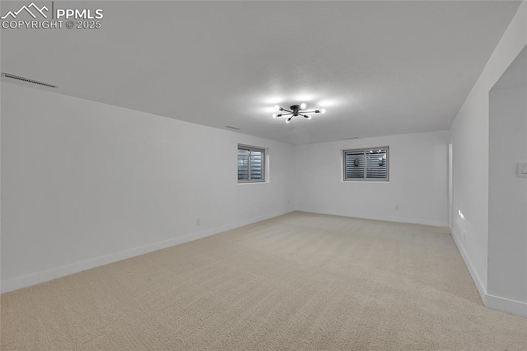 Image 34 of 40: Empty room featuring light colored carpet and baseboards