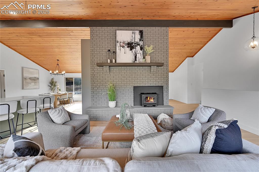 Image 4 of 40: Living room featuring a chandelier, wooden ceiling, light wood-style floori