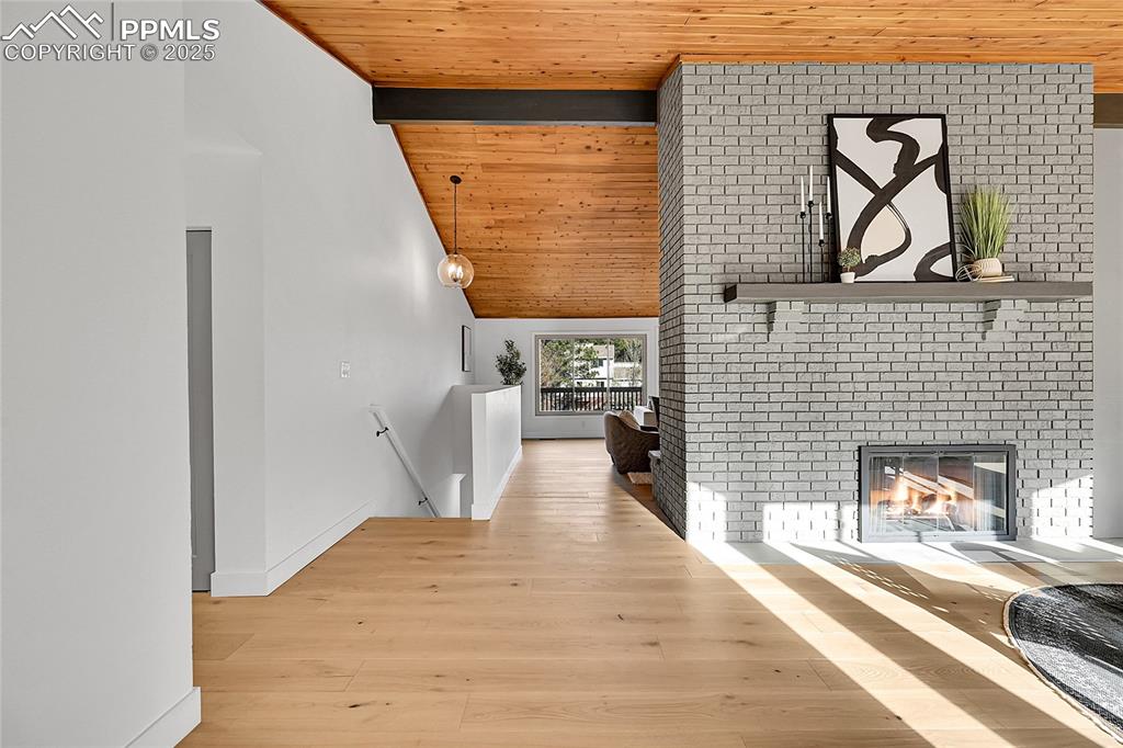 Image 7 of 40: Corridor with a wooden ceiling with exposed beams, an upstairs landing, lig