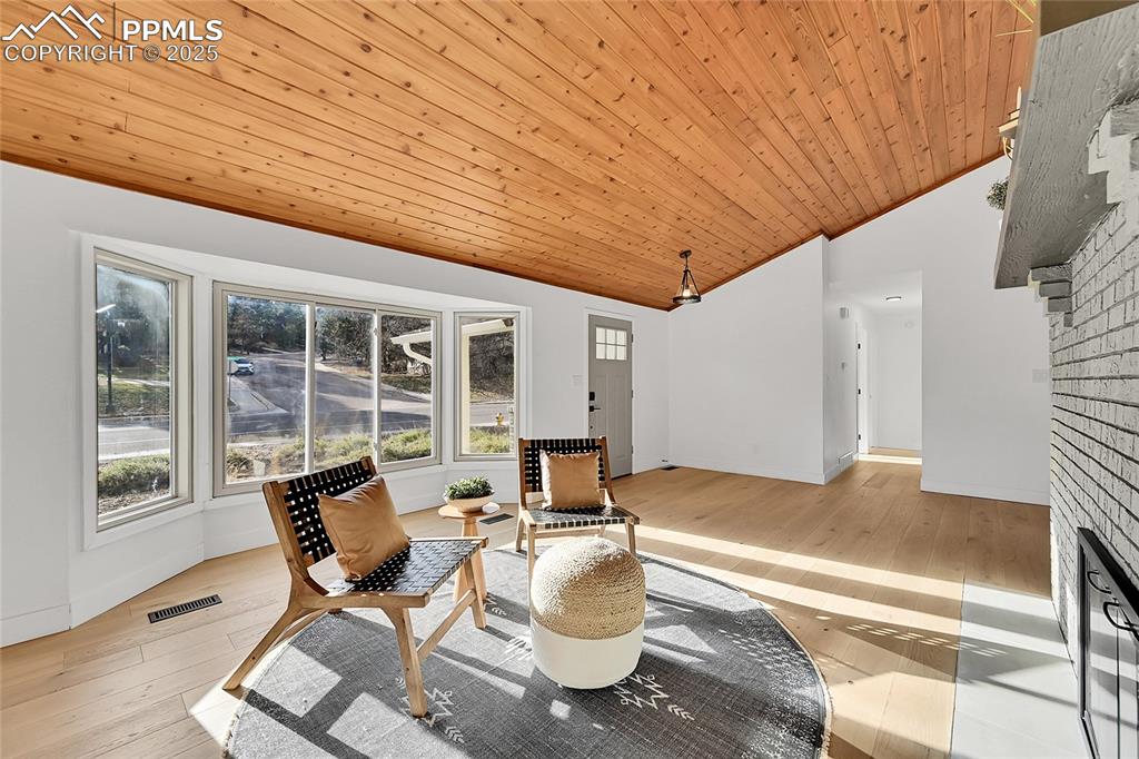 Image 9 of 40: Living area featuring light wood finished floors, lofted ceiling, and woode