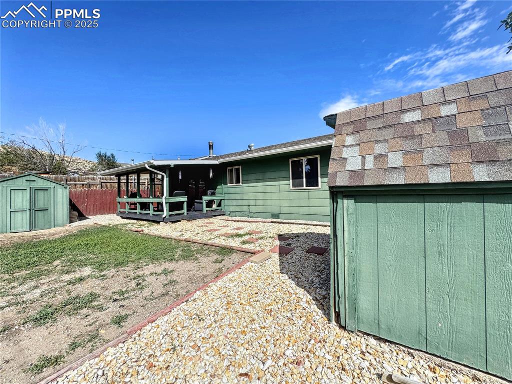 Image 6 of 8: Back of property featuring a storage unit
